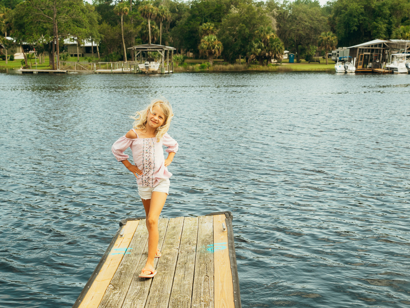 girl walking on pier of fiddlers resort  on river