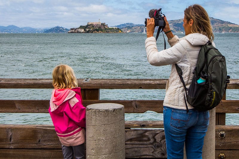 woman taking photo of Fisherman's Wharf, San Francisco