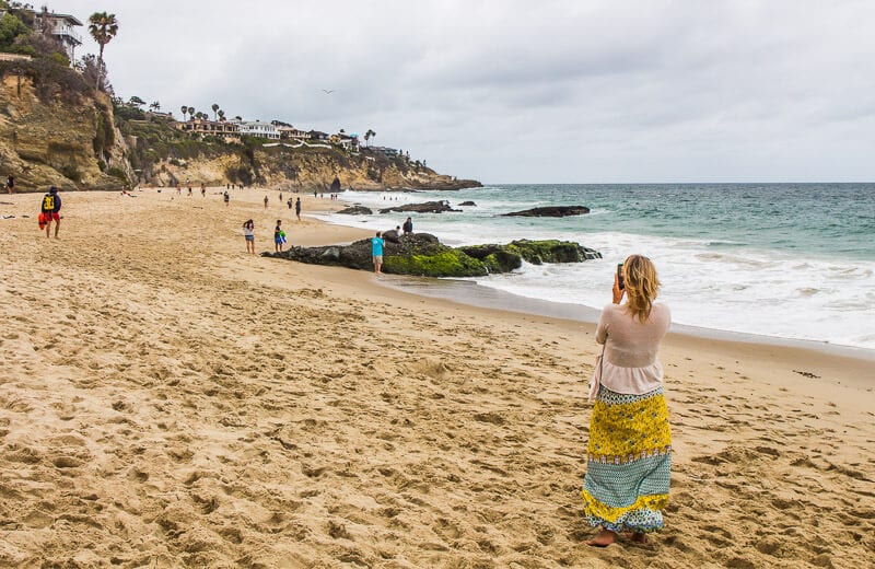 woman taking photo on 1,000 steps beach, Orange County