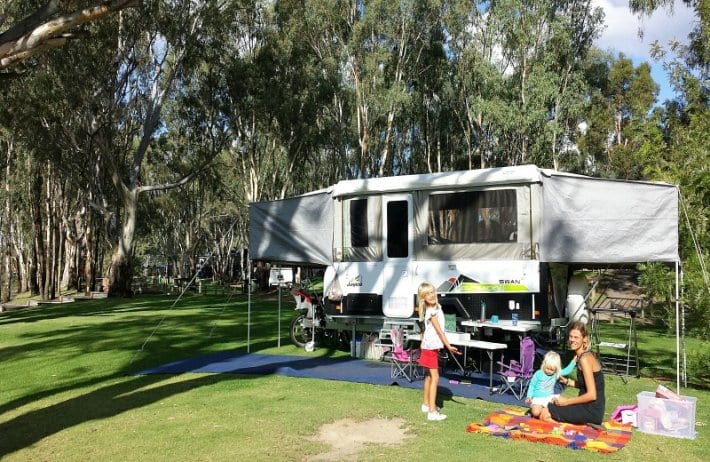 family on grass out front of jayco caravan