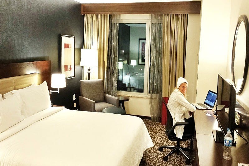 Hilton Garden Inn hotel room with woman at desk