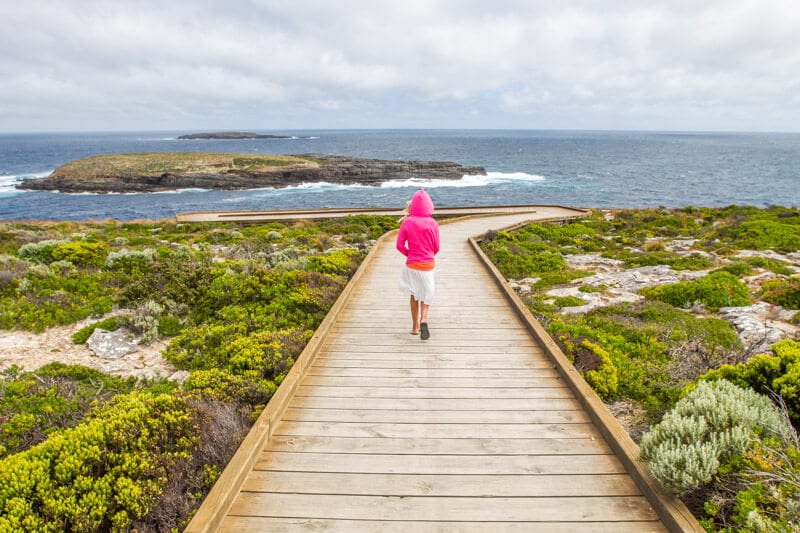 girl walking on boardwalk towards Admiral's Arch