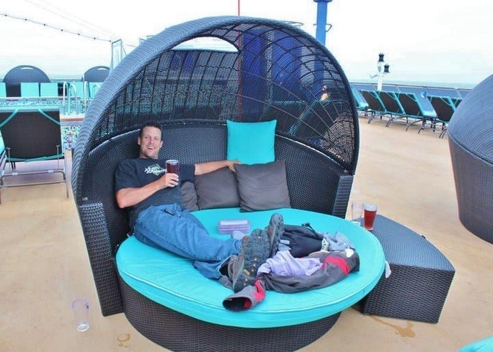 a man sitting on a lounge outside