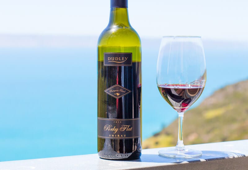 bottle and glass of Dudley Wines with ocean views