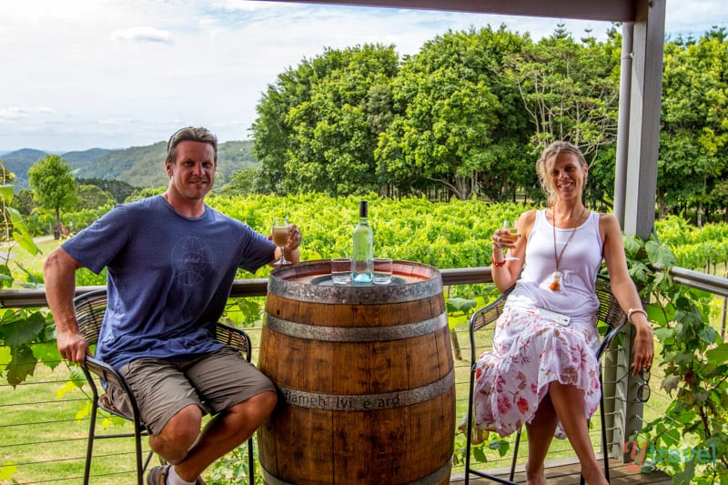 man and woman sitting at wine barrel in Flame Tree Vineyard -