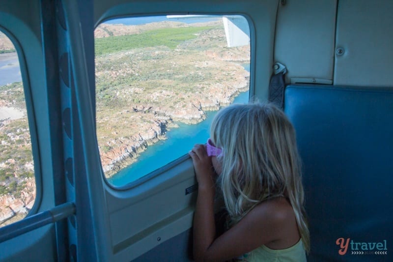 young girl looking out window on scenic flight over buccaneer archipelago