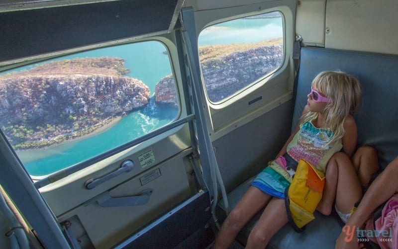 young girl looking out sea plane window at horizontal falls