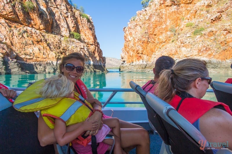 people sitting on a boat wearing life jackets