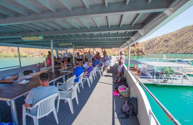 people sitting on tables on a boat