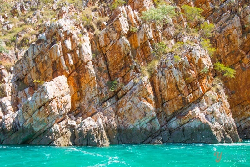 orange cliffs beside turquoise water of the kimberley