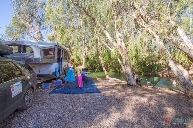 family out front o caravan beside river at gregory downs