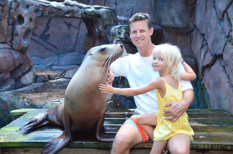 man and child having a photo with a seal