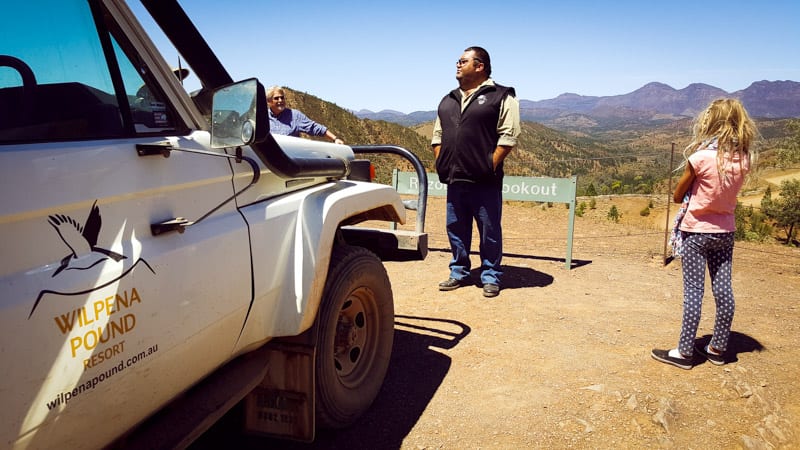 man standing next to a truck in the desert