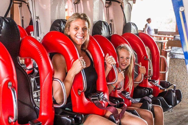 mother and child sitting in roller coaster seats ready to go