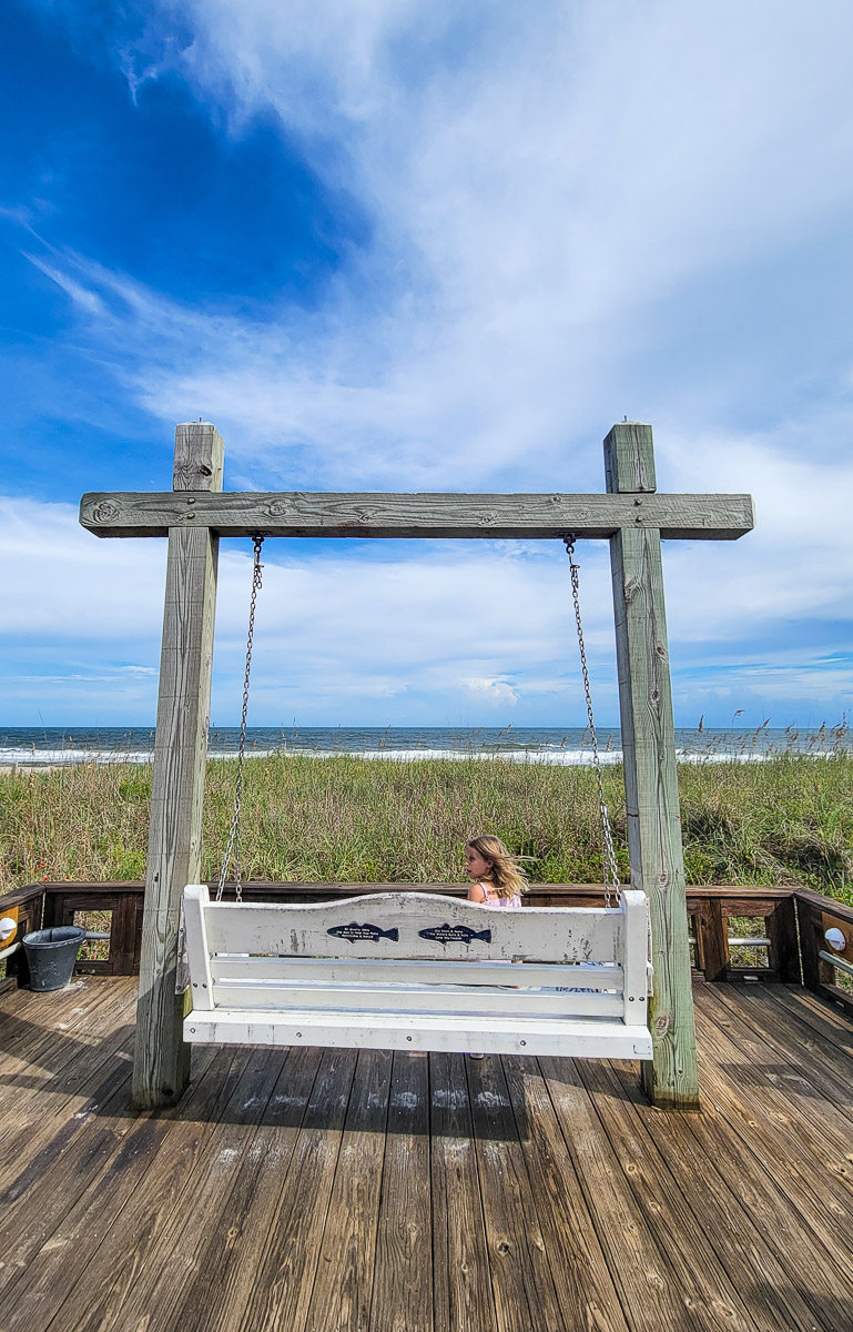 girl sitting on a swinging chair on the beach