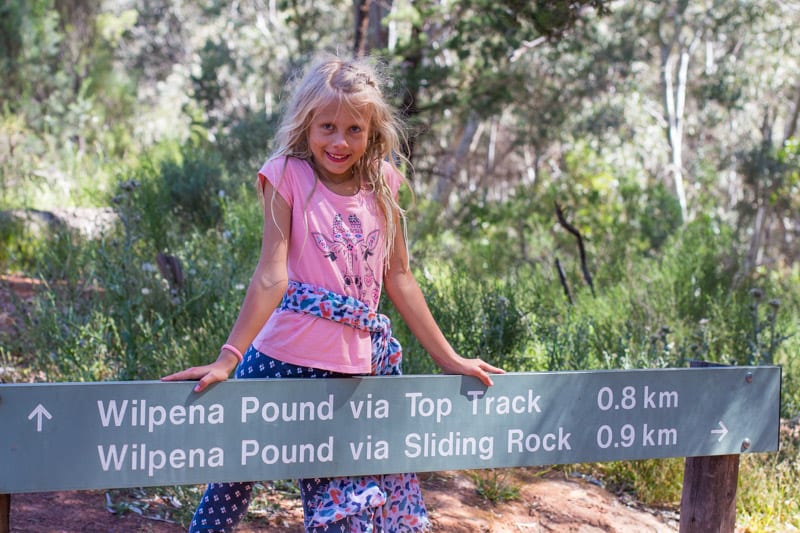 girl standing behind a sign