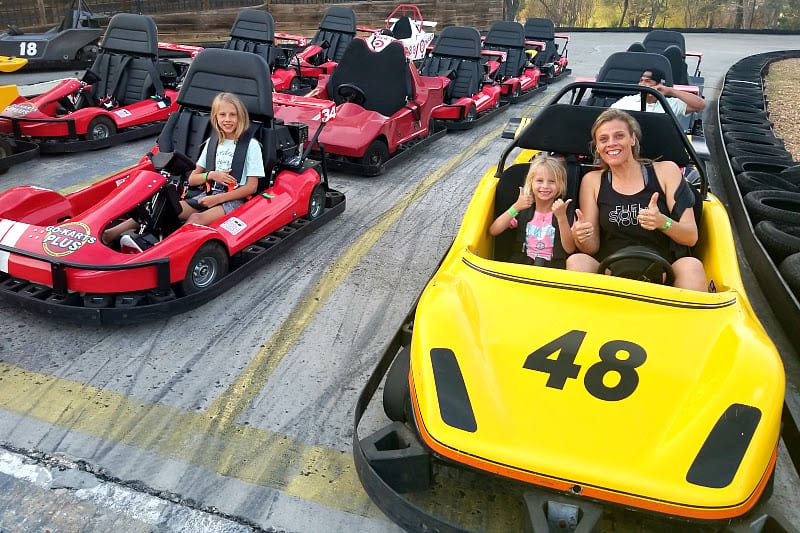 family sitting in go karts ready to race