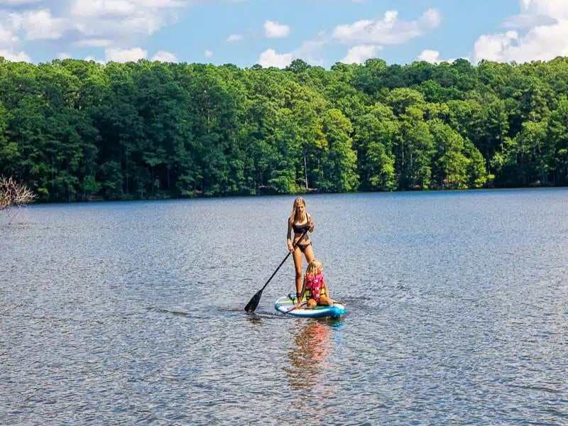 girls on paddle board on lake johnson