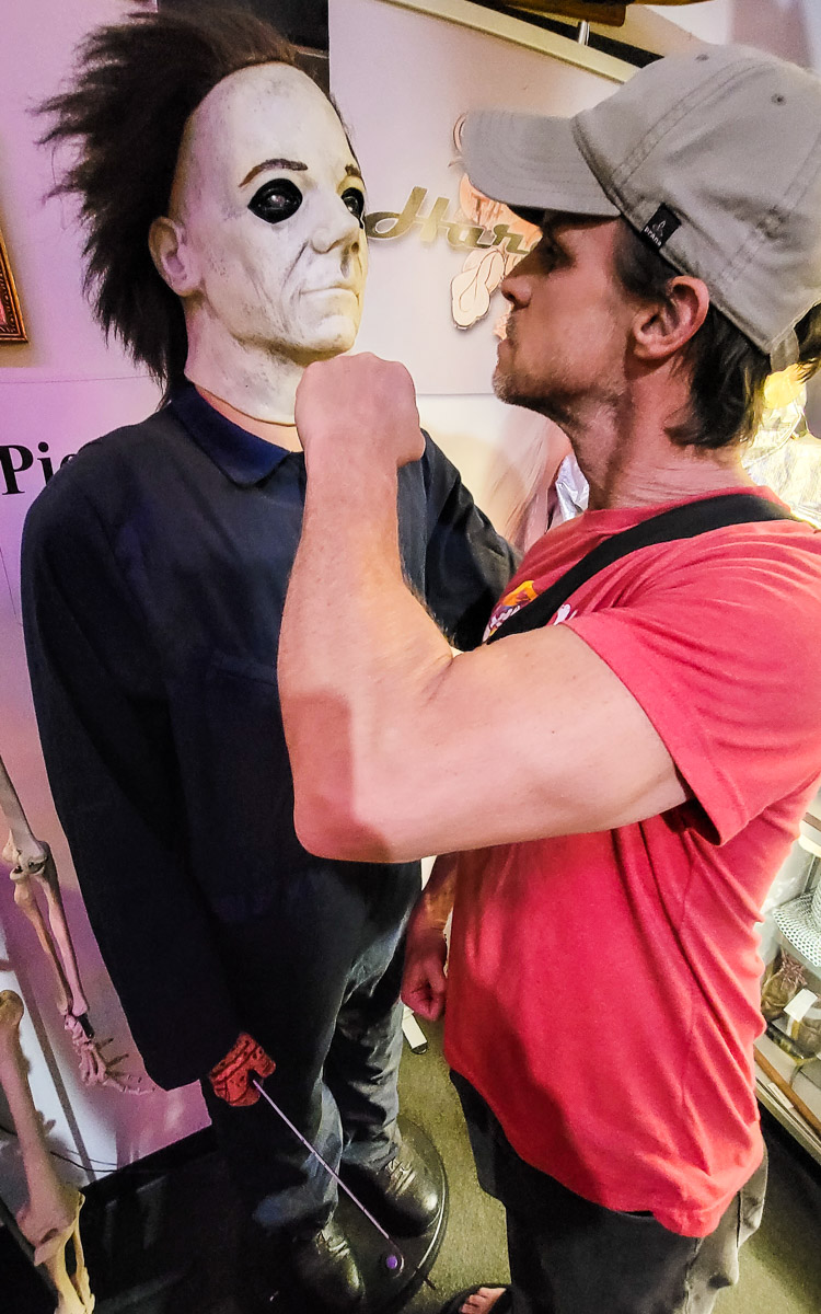 man with fist in front of jason mask