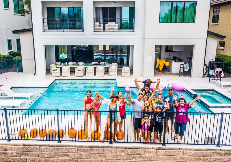 group of friends in front of swimming pool vacation rental