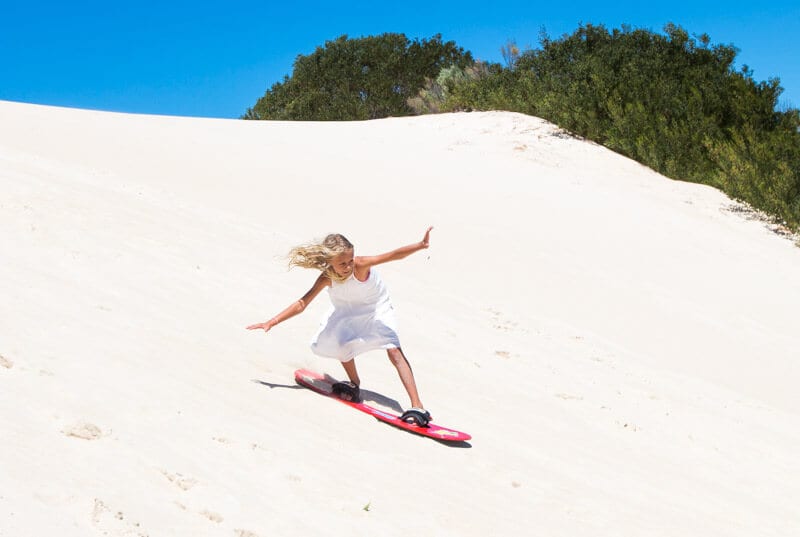 girl Sandboarding the Little Sahara sand dunes 