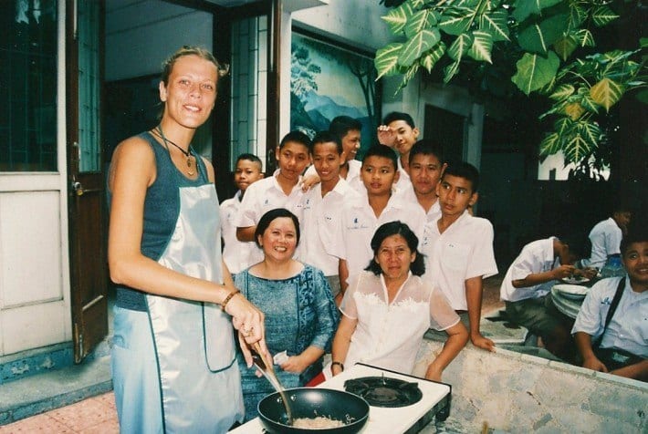 woman learning how to cook with thai students