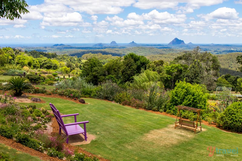 a bench in a park overlooking glasshouse mountains