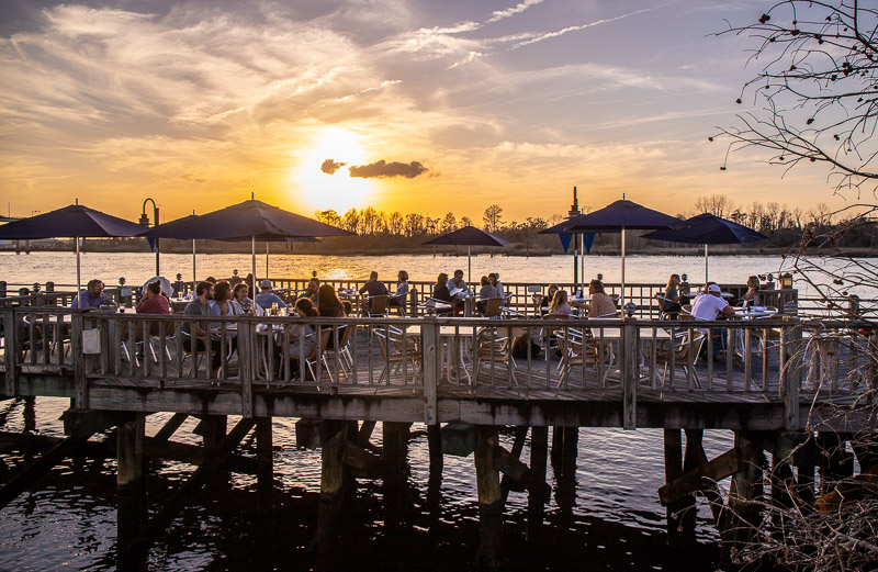 people on a board walk next to a body of water