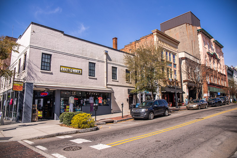 A city street with cars parked on the side of a building