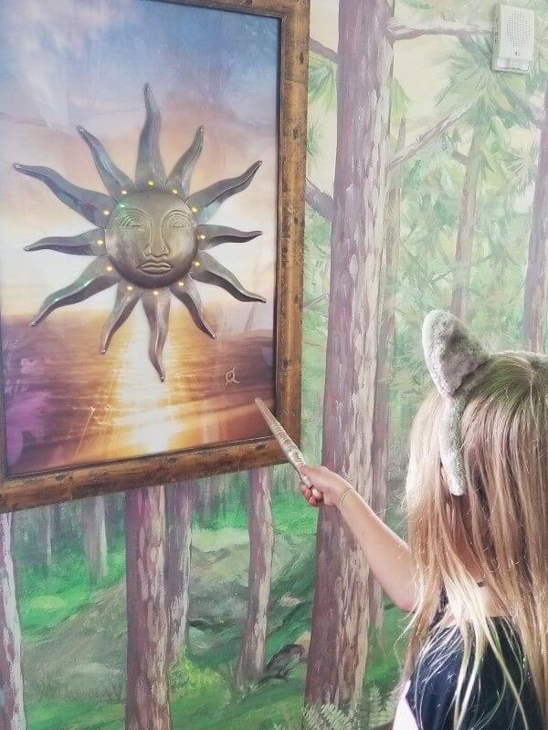 girl waving wand at sun mural