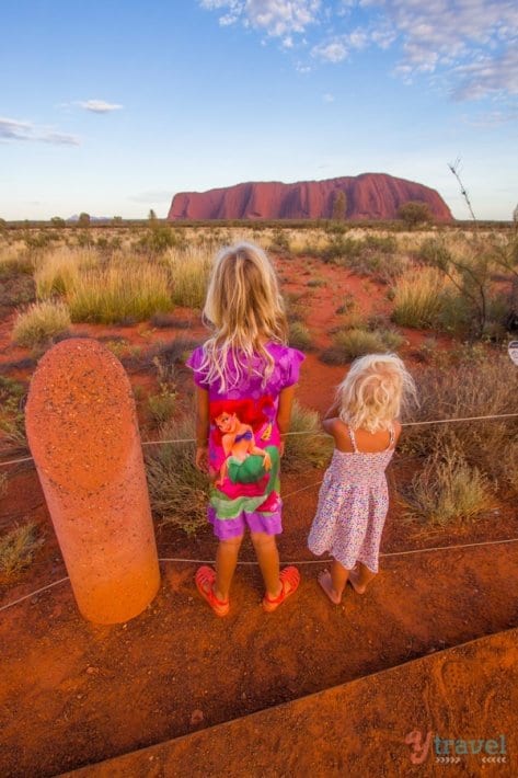 two girls looking at Uluru during Sunrise 