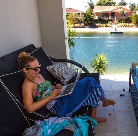 woman working on computer by pool