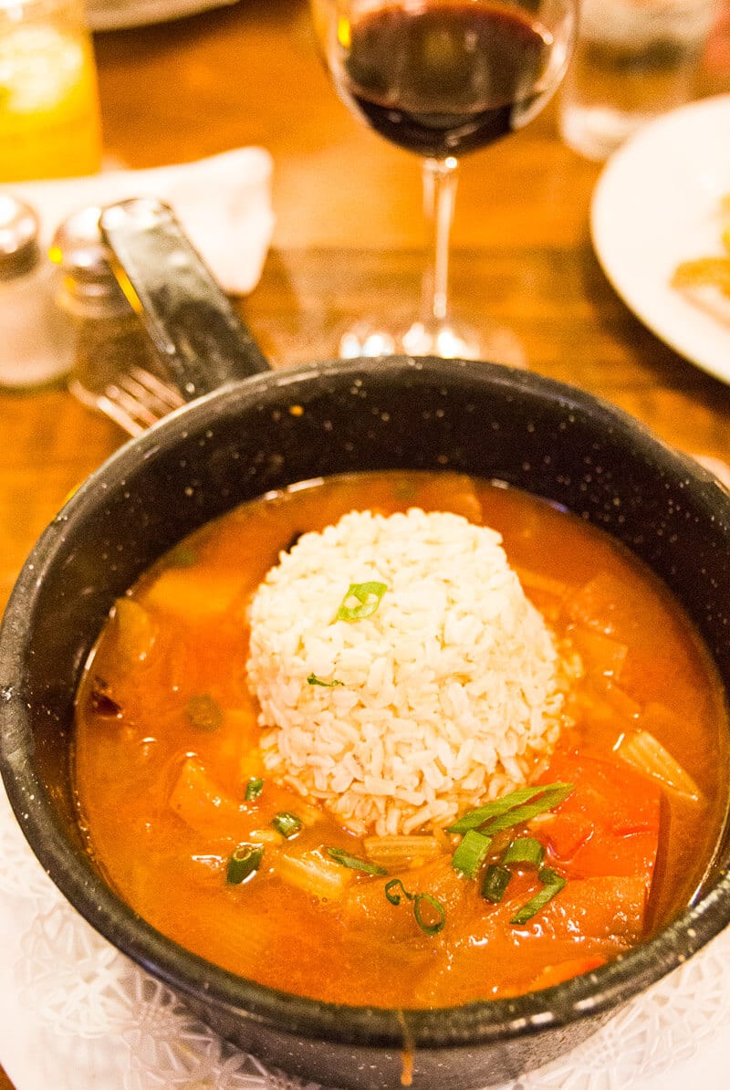 fisherman's stew and glass of red wine on table