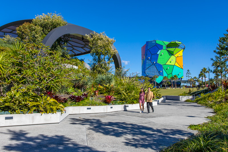 A couple walking with gallery building in the background, Surfers Paradise