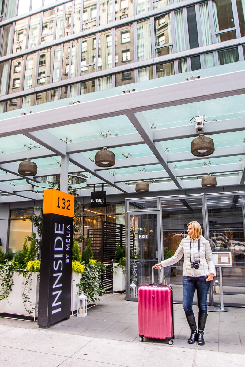 lady with suitcase outside The stylish INNSIDE New York Nomad hotel in NYC.