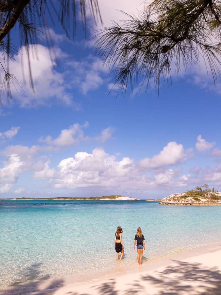 Two young girls standing in shallow water at the beach