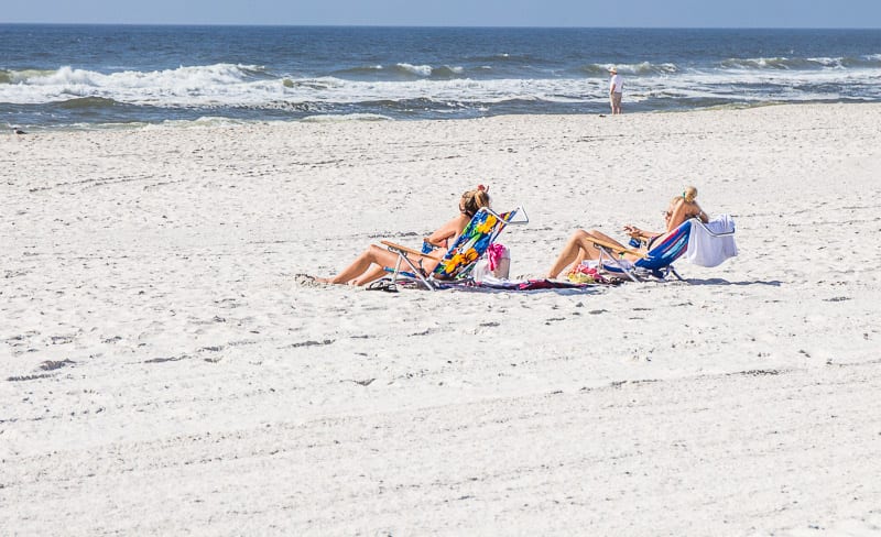 people sitting on lounge chairs on orange beach